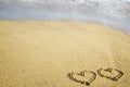 Two hearts written on sand