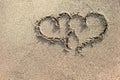 Two hearts written on the sand.