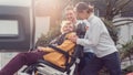 Two helpers picking up disabled senior woman for transport Royalty Free Stock Photo