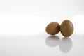 Two hen or chicken eggs isolated on white background with reflex on glass