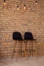 Two high bar stools near a brick wall. Modern furniture. Chair in loft style. Room interior Royalty Free Stock Photo