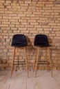 Two high bar stools near a brick wall. Modern furniture. Chair in loft style. Room interior Royalty Free Stock Photo