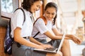 two high school students surfing the internet using a laptop Royalty Free Stock Photo