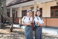 Two high school teenagers standing with crossed arms