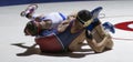 Two high school wrestlers grapling during a match