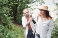 Two hikers with backpacks on the back in nature. Man and woman holding hands while walk on a summer day Royalty Free Stock Photo