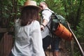 Two hikers with backpacks on the back in nature. Man and woman holding hands while walk on a summer day Royalty Free Stock Photo