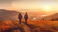 Two hikers with backpacks enjoying sunset view from top of a mountain