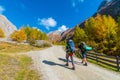 Two hikers with backpacks on a road to Grossglockner in autumn, Tyrol, Austria