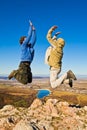 Two hikers jumping cheerfully on mountain summit