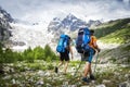 Two hikers with large backpacks in mountains. Tourists hike on rocky mounts. Leisure activity on mountain trek