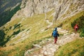 Two hikers making their way down a rocky mountain trail Royalty Free Stock Photo