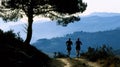 Two hikers pause for a water break on a winding mountain trail. toned legs and strong posture showcase the physical