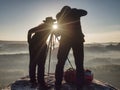 Two hikers taking pictures and talk on top of mountain. Two photographers Royalty Free Stock Photo