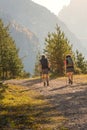 Two hikers at the trail in Dolomites at the national park Three Peaks Tre Cime, Drei Zinnen during sunset at direct light, South