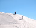 Two Hikers on a trail walking through snow. Winter landscape in Carapathian Mountains, Romania Royalty Free Stock Photo