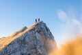 Two hikers walking along a mountain ridge route, the sun on the blue sky Royalty Free Stock Photo