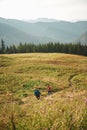 Two hikers walking down a trail together in the mountains Royalty Free Stock Photo