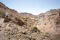 Two hikers walking on a scenic mountain trail in Qeshm, Iran