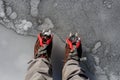 Two hiking boots with crampons on the ice. Mountain sport accessories concept Royalty Free Stock Photo