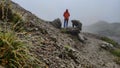 two hiking men, drops on grass in focus Link Dolomites in cloudy, nasty weather , Alps in Austria. Mountain paths for hiking and