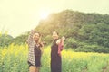 Two hipster woman traveling and enjoying with flower field together, relaxing good time sunny day. Royalty Free Stock Photo