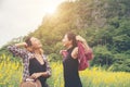Two hipster woman traveling and enjoying with flower field together, relaxing good time sunny day. Royalty Free Stock Photo