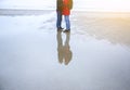 Two hipsters standing on the cold beach. Couple hugging and holding hands. Love story near the ocean. Winter season on the sea. Royalty Free Stock Photo