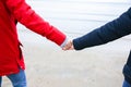 Two hipsters standing on the cold beach. Stylish couple hugging and holding hands. Love story near the ocean. Winter season on the Royalty Free Stock Photo