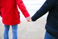 Two hipsters standing on the cold beach. Stylish couple hugging and holding hands. Love story near the ocean. Winter season on the Royalty Free Stock Photo