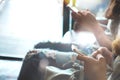 Two of hipsters woman sitting on sofa holding en hands and using mobile phone. Royalty Free Stock Photo