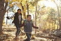Two Hispanic children have fun running in a forest