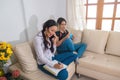 Two Hispanic girls sitting on the couch talking to customers on the phone Royalty Free Stock Photo