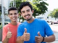 Two hispanic guys showing thumbs in city Royalty Free Stock Photo