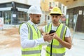 Two hispanic men architects using smartphone standing at street Royalty Free Stock Photo