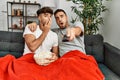 Two hispanic men couple watching movie sitting on sofa at home Royalty Free Stock Photo