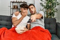 Two hispanic men couple watching movie sitting on sofa at home Royalty Free Stock Photo