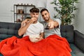 Two hispanic men couple watching movie sitting on sofa at home Royalty Free Stock Photo