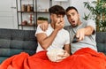 Two hispanic men couple watching movie sitting on sofa at home Royalty Free Stock Photo