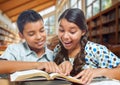 Two Hispanic School Kids Having Fun Studying in a School Library Royalty Free Stock Photo