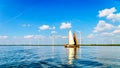 Two Historic Wooden Botter Boats in Full Sail near a Wind Farm along the Shore of Veluwemeer Royalty Free Stock Photo