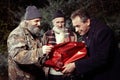 Two homeless men rewarding man in suit for gift of food in christmas time Royalty Free Stock Photo