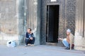 Two homeless people earn their living by begging at church doors