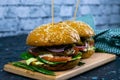 Two homemade beef burgers with mushrooms, micro greens, red onion on wooden cutting board Royalty Free Stock Photo