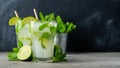 Two homemade lemonade or mojito cocktail with lime, mint and ice cubes in a glass on a dark stone table. Fresh summer drink. With Royalty Free Stock Photo