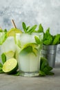 Two homemade lemonade or mojito cocktail with lime, mint and ice cubes in a glass on a light stone table. Fresh summer Royalty Free Stock Photo