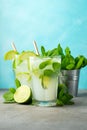 Two homemade lemonade or mojito cocktail with lime, mint and ice cubes in a glass on a light stone table. Fresh summer Royalty Free Stock Photo