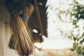 Two homemade straw brushes hang crosswise under slate roof