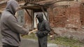 Two hooligans attacking each other with bat and fists on street