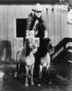 A two horse power ride, Cowboy riding two ponies Royalty Free Stock Photo